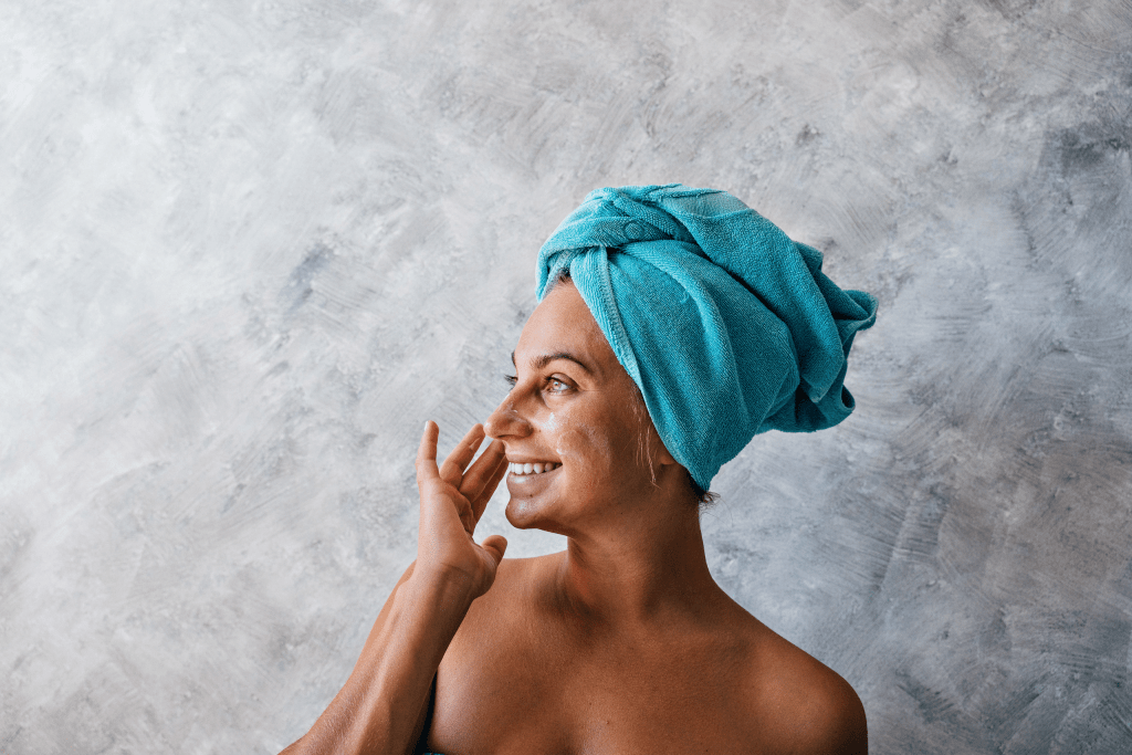 Smiling woman with towel wrapped on head in bathroom