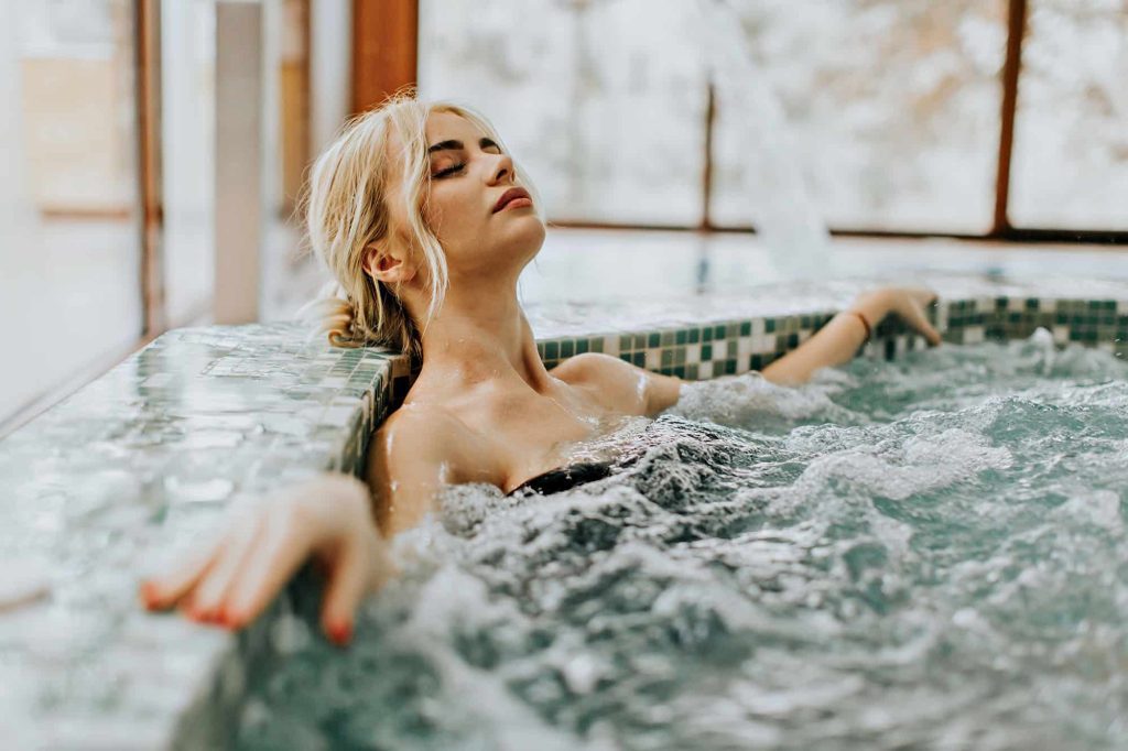 Woman relaxing in a luxurious indoor hot tub
