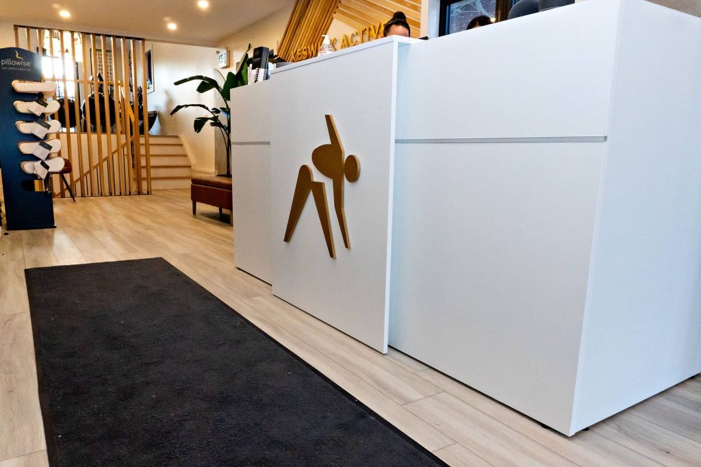 Modern fitness studio reception with yoga logo and wood accents