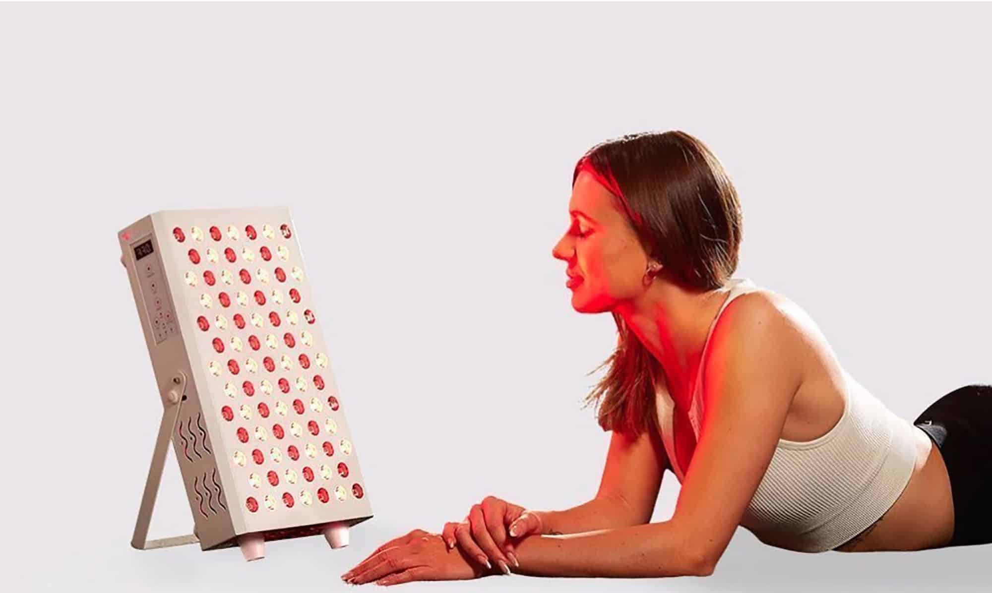 Woman using red light therapy device for skin treatment